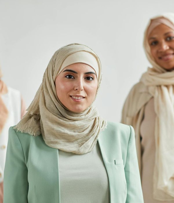 Diverse group of people smiling in a bright, modern yoga studio.